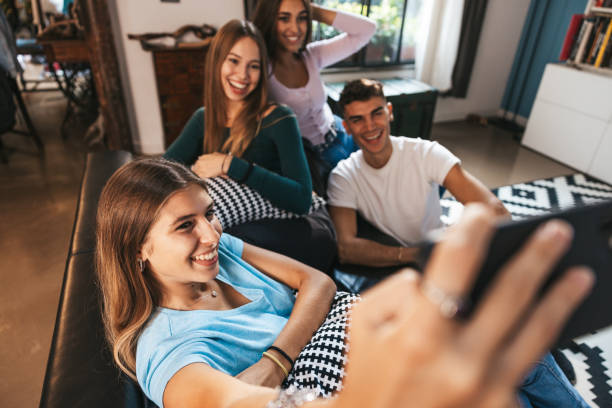 istock Four friends relaxing on the couch and taking a selfie 1620546798