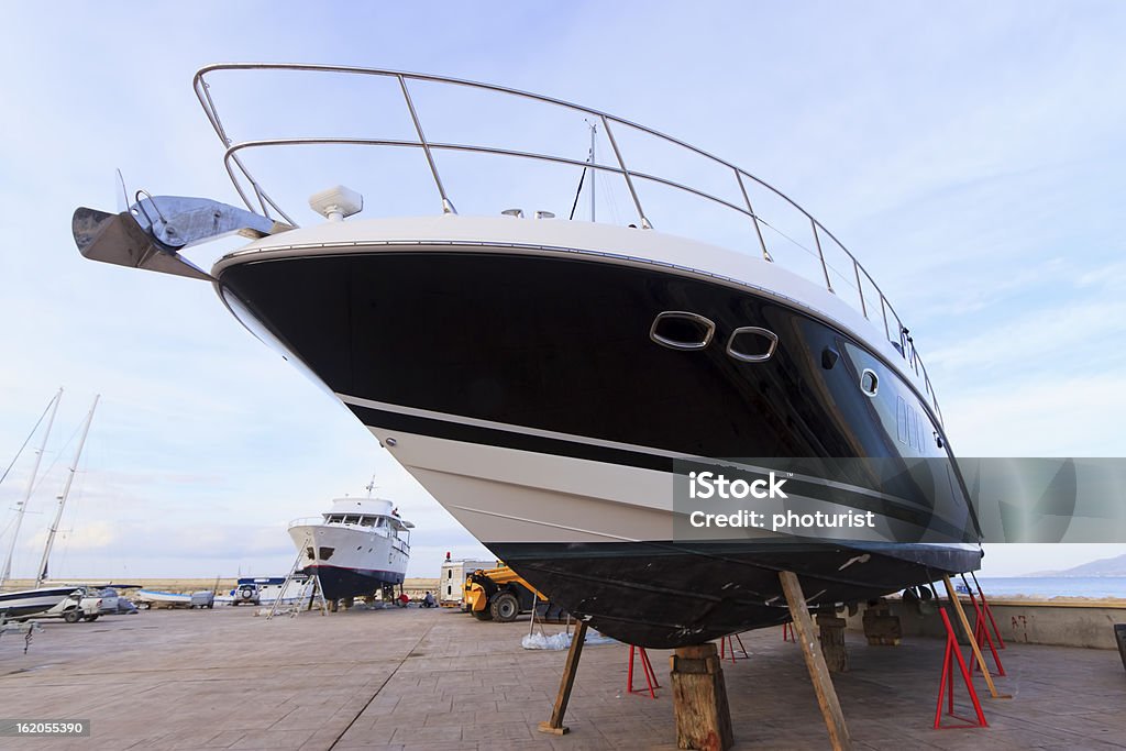 Luxury motor yacht beached for annual check Examining Stock Photo