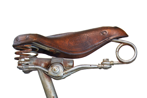 Vintage weathered brown leather bicycle seat isolated on a white background