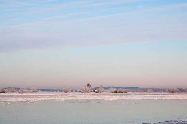 Red cotttage by frozen lake
