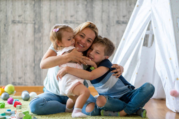 istock Mother embracing her children at home 1620595943