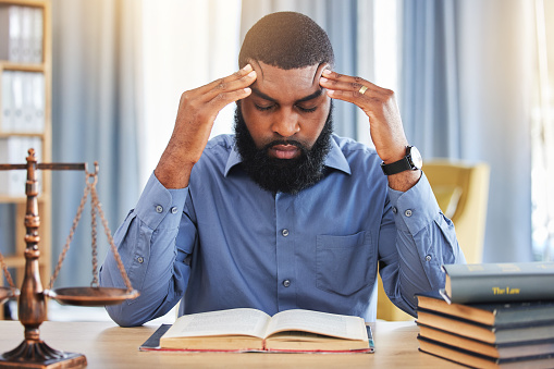 Black man, lawyer and stress of headache in office with worry, pain and frustrated with challenge of court case in law firm. Confused advocate, tired attorney and fatigue from legal research analysis