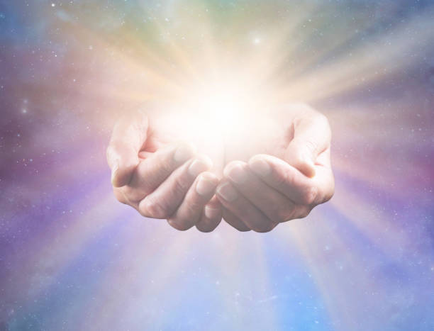 Connect with Divine Intelligence and All That Is mature male healers cupped hands with bright healing star light radiating outwards against celestial background ideal for a spiritual holistic healing theme spirit guides stock pictures, royalty-free photos & images