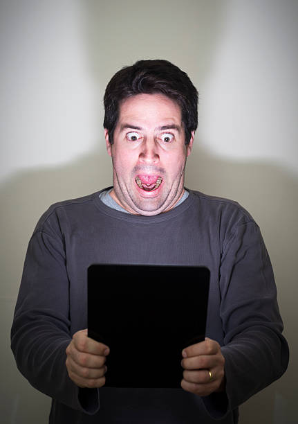 istock Man is shocked by what he sees on a tablet 162064762