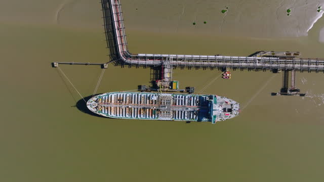 Aerial view of Oil tanker in industrial port at unloading of bulk contents in Dartford, Essex, UK