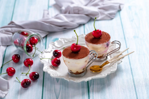 Traditional Italian dessert tiramisu with cherries in a glass Traditional Italian dessert tiramisu with cherries in a glass tiramisu glass stock pictures, royalty-free photos & images