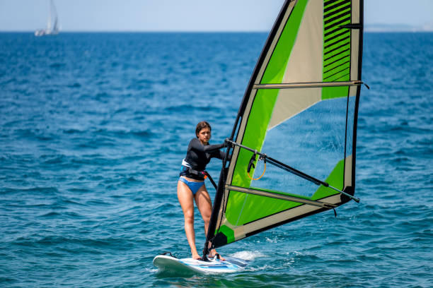 istock Young girl windsurfing in a blue ocean 1620664240
