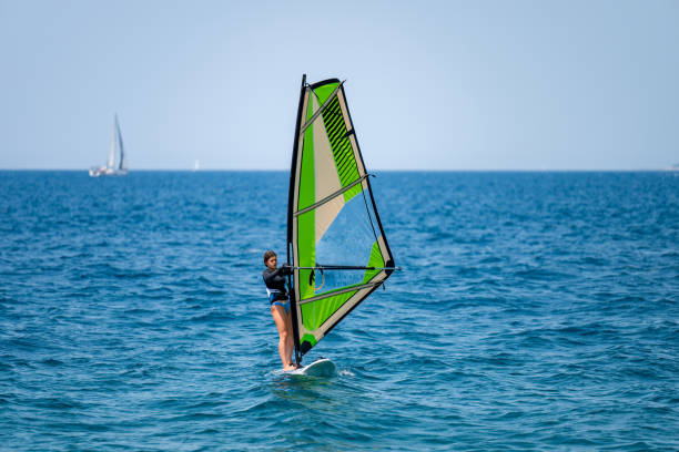 istock Young girl windsurfing in a blue ocean 1620664757