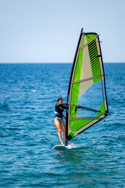 istock Young girl windsurfing in a blue ocean 1620664758
