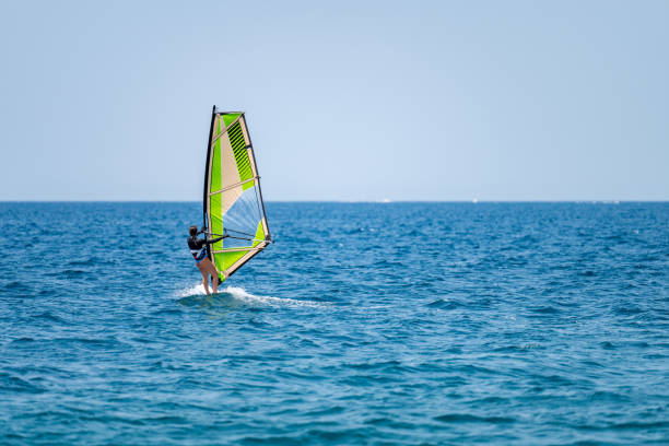 istock Young girl windsurfing in a blue ocean 1620665311
