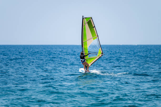 istock Young girl windsurfing in a blue ocean 1620665857