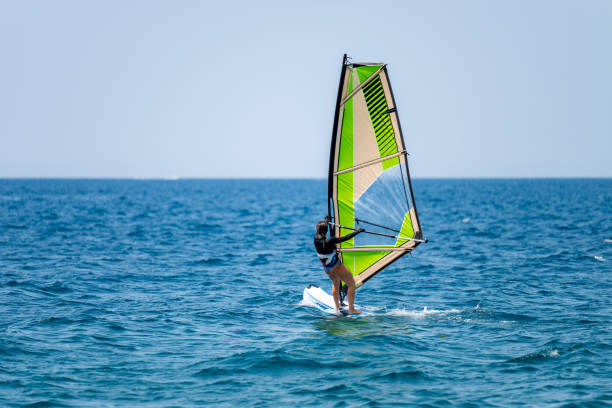 istock Young girl windsurfing in a blue ocean 1620665859