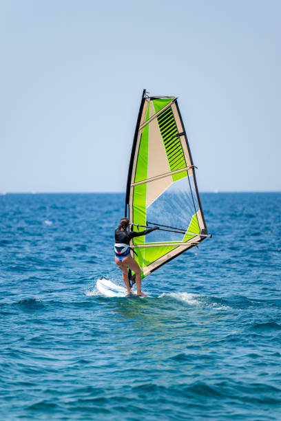 istock Young girl windsurfing in a blue ocean 1620665860