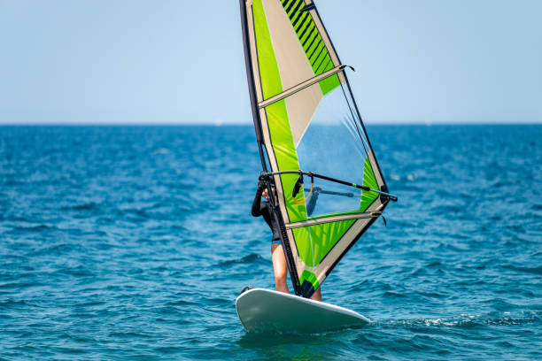 istock Young girl windsurfing in a blue ocean 1620667989