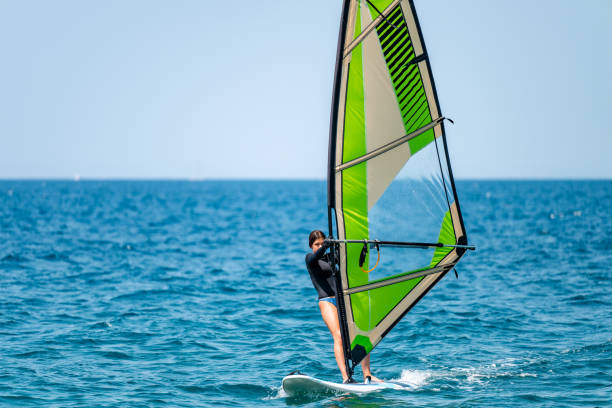 istock Young girl windsurfing in a blue ocean 1620668526