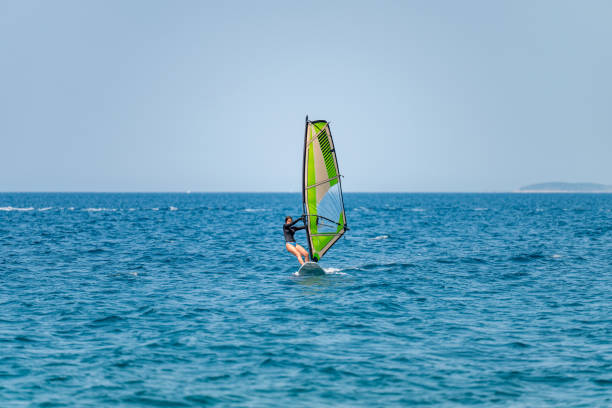 istock Young girl windsurfing in a blue ocean 1620670105