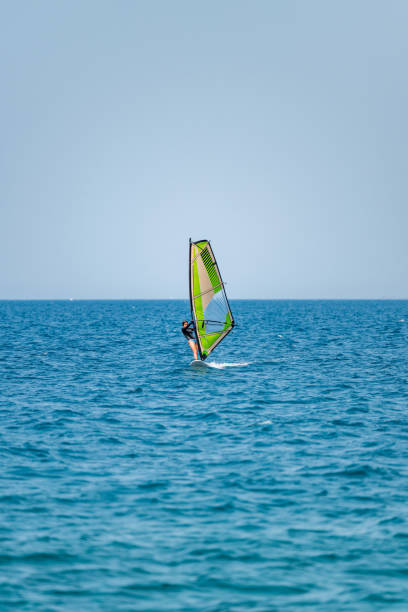 istock Young girl windsurfing in a blue ocean 1620670617