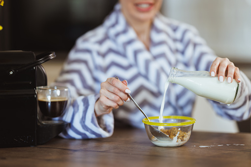 Cropped shot of a woman preparing a cereal for breakfast at home.