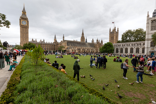 London, UK: Aug 14, 2023:  People walking and resting during a summer day in the Parliament Square Garden at the City of Westminster, London, England, UK.