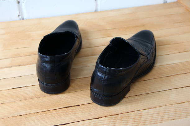 istock Black leather boots on a wooden background 1620733057