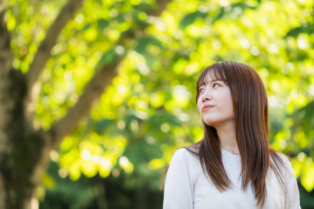 istock Young woman standing in fresh green 1620738182
