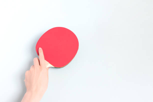 istock Female hand hold racket for ping pong on a blue background. 1620753334