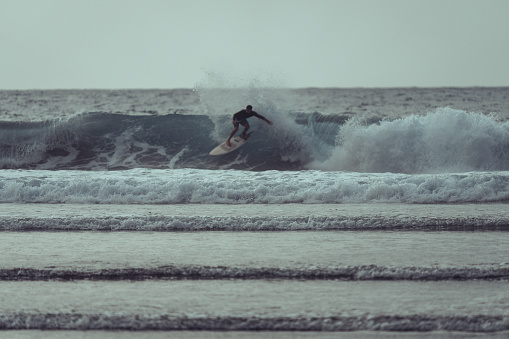 Taganana, Spain, June 29, 2023: Surfers enjoying big waves at sunset on June 29 2023 on the beach of Taganana, Tenerife, Canary Islands, Spain.