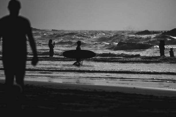 Taganana, Spain, June 29, 2023: Surfers enjoying big waves at sunset on June 29 2023 on the beach of Taganana, Tenerife, Canary Islands, Spain.