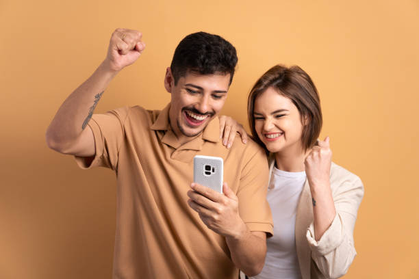 istock couple raising arms and celebrating 1620784312
