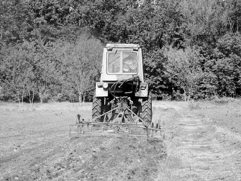 Tractors sowing on agricultural field on a beautiful sunny spring day.