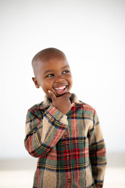 istock Cute African boy looking away with hand on his chin 1620800473