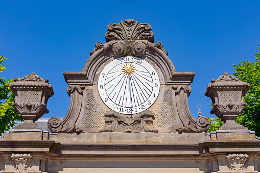 Amsterdam, Netherlands - May 15, 2018: White Sundial Clock With Gold Sun at Museum Garden Landmark.