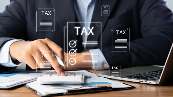 Tax and Vat concept. Government, state taxes concept.  Businesman using laptop to complete Individual income tax return form online for tax payment.  Data analysis, paperwork, financial research.