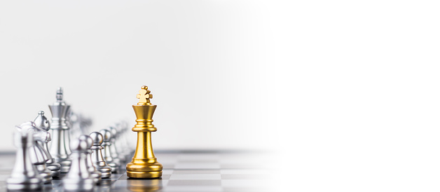 Leader, business strategy and planning concept, Gold Chess king figure on Chessboard and surrounded by a number of fallen silver chess pieces against opponent or enemy. Conflict, tactic, politic.