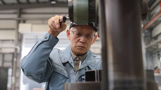 Senior Industrial Worker Working At Factory