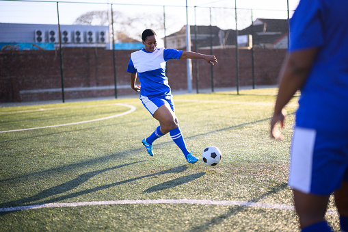 Man preparing to kick the ball on the soccer field.