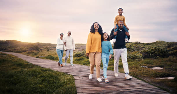 Black family, walking or sunset with parents, children and grandparents spending time together in nature. Spring, love or environment with kids and senior relatives taking a walk while bonding Black family, walking or sunset with parents, children and grandparents spending time together in nature. Spring, love or environment with kids and senior relatives taking a walk while bonding big family sunset stock pictures, royalty-free photos & images