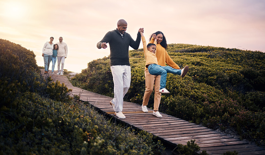 Black family, walking or sunset with parents, kids and grandparents spending time together in nature. Spring, love or environment with children and senior relatives taking a walk while bonding