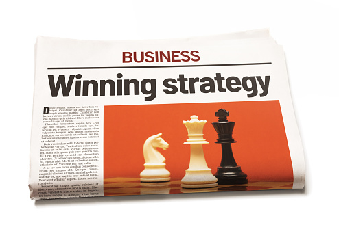 Winning strategy, announces a newspaper business section in bold font, over a picture of checkmate in a chess game. Photo and design are by the photographer, so this image is free of third-party copyright and may be used for any purpose.