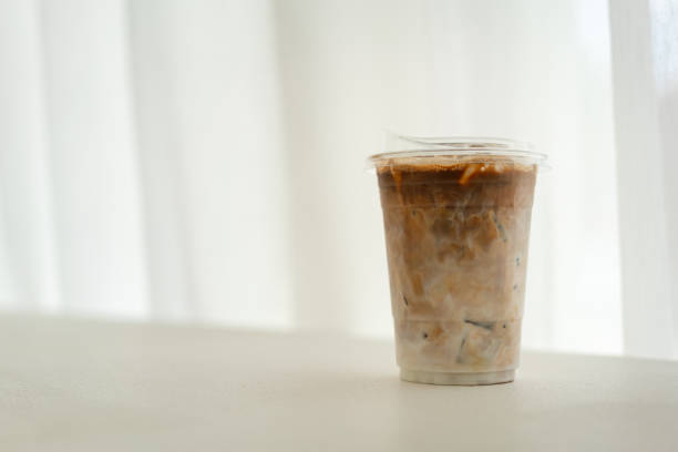 istock An iced milk coffee cup on white curtain background. 1620886436