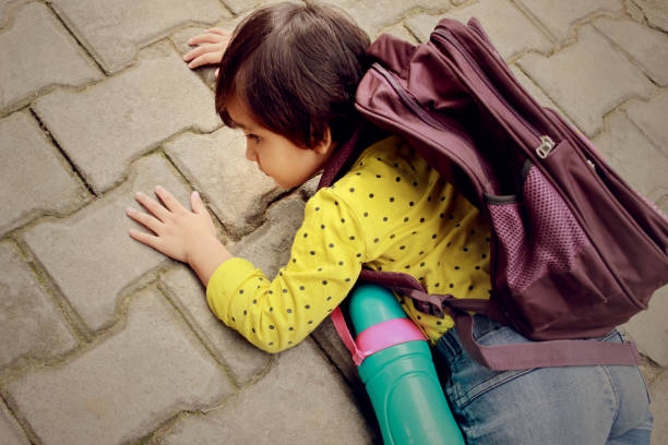 istock Schoolgirl falling on road during day time 1620887271