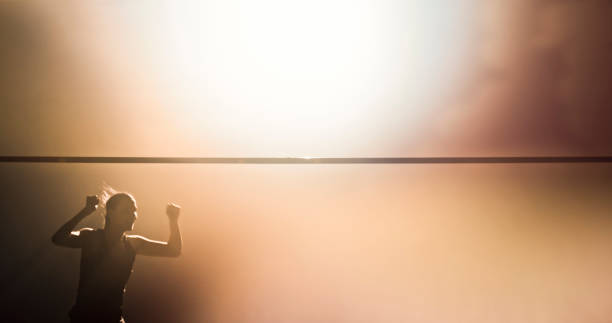 Athlete woman celebrating doing high jump success in sports hall.