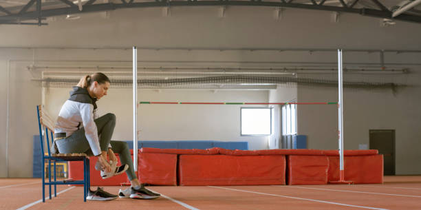 Athlete airborne while performing high jump on sunny day at open-air track. Concept of action shot, peak athletic moment, pole vault motion, overcoming gravity