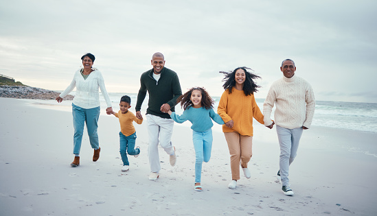 Grandparents, parents and children running on beach enjoy holiday, travel vacation and weekend together. Relax, smile and happy family portrait holding hands for bonding, quality time and fun by sea
