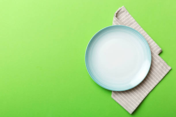 istock Top view on colored background empty round blue plate on tablecloth for food. Empty dish on napkin with space for your design 1620894026
