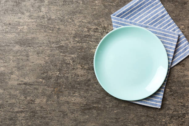 istock Top view on colored background empty round green plate on tablecloth for food. Empty dish on napkin with space for your design 1620894033
