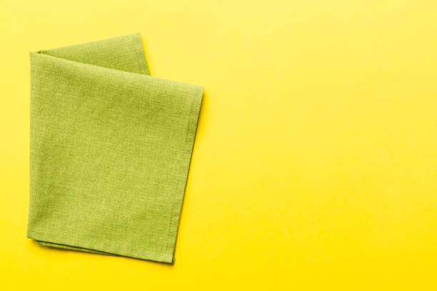 istock top view with green kitchen napkin isolated on table background. Folded cloth for mockup with copy space, Flat lay. Minimal style 1620894577