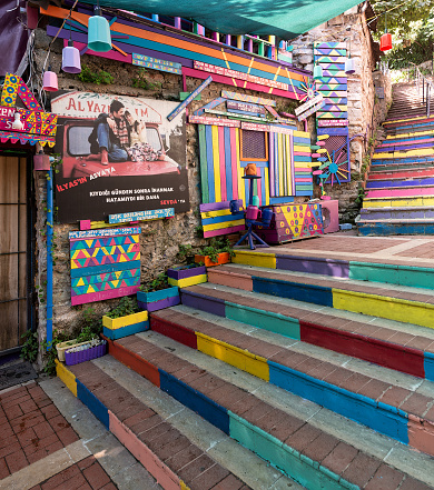 Exterior daytime shot of stone cafe decorated with multicolored panels colorful stairs, and canopy in Balat District, Istanbul, Turkey