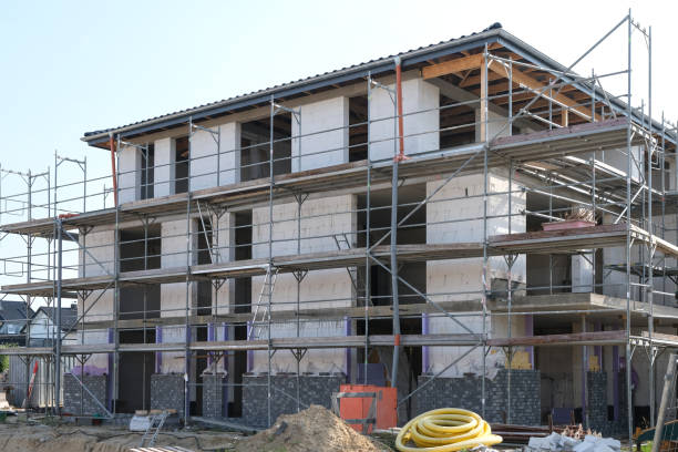 istock Construction site with equipment, tools and materials and a scaffolded shell of a house 1620909813