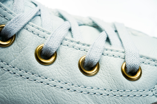 shoelaces tied on sneakers with metal eyelets, close-up shot, object isolated on a white background